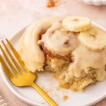 Finished Banana Bread Cinnamon Rolls with cream cheese frosting drizzled on top.