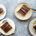 Chocolate Eclair Cake slice with raspberries and mint garnish